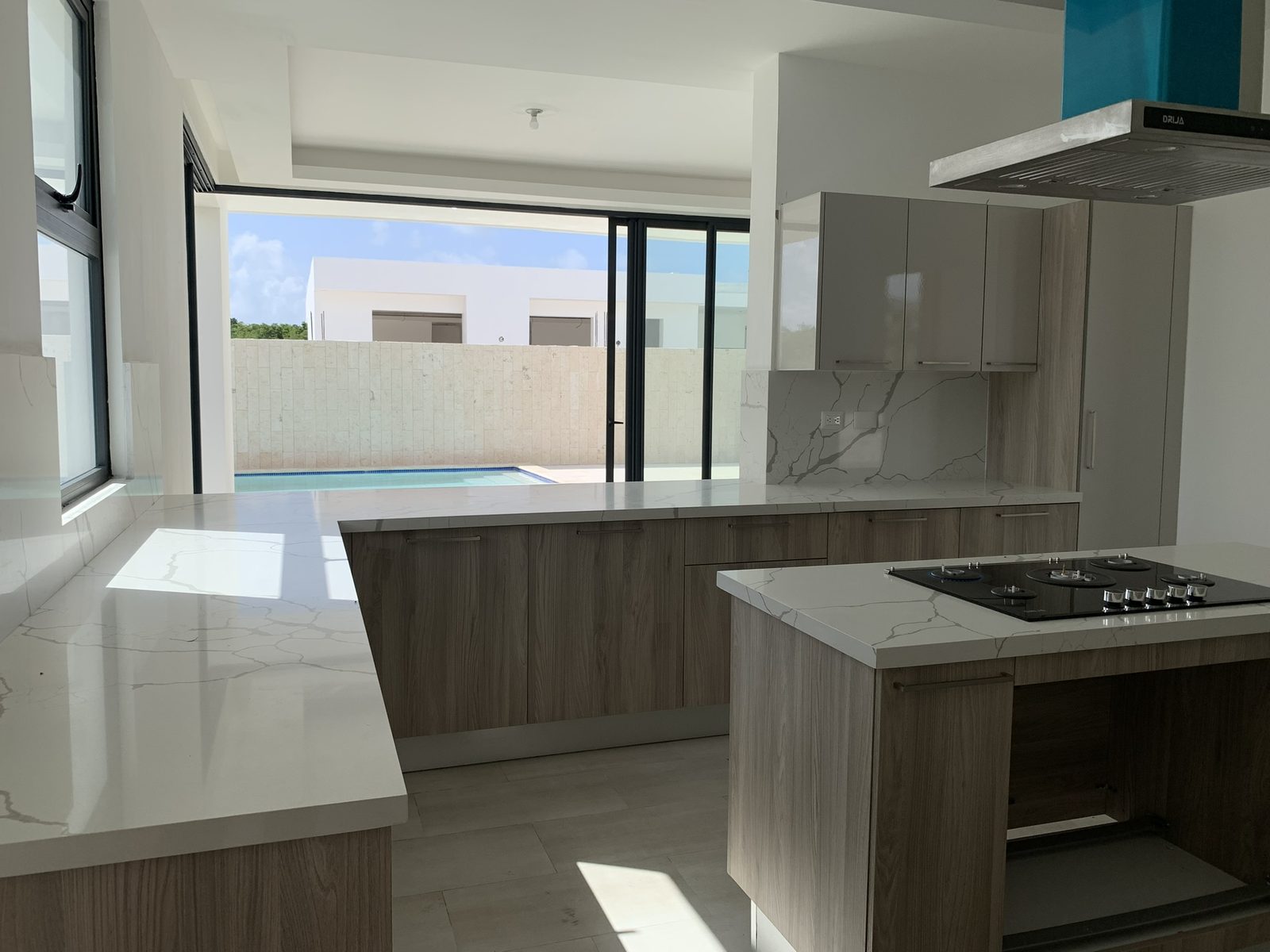 Cocina abierta con isla y vista directa a la piscina